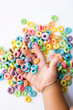 mano de niño jugando con cereal dulce de colores