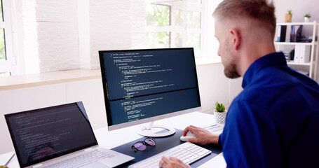 Computer Programmer Writing Program Code On Computer
