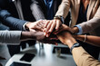 © Jasmina - Diverse team of businesspeople joining their hands together in unity, coming together in success.