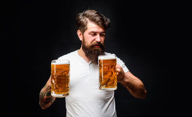 Satisfed man with two mugs of beer. Alcohol. Bar, pub or restaurant advertising. Handsome man enjoying cold pint of beer. Brewing. Beer time. Oktoberfest celebration. Bearded man tasting draft beer.