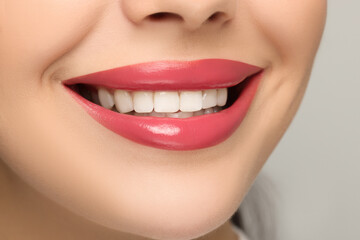 Wall Mural - Smiling woman with healthy teeth on light background, closeup