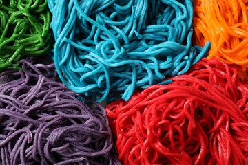 Wall Mural - Rolled spaghetti painted with different food colorings as background, closeup