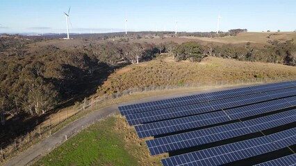Wall Mural - aerial drone pullback reverse view of a hybrid wind and solar farm for renewable clean energy supply