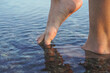Closeup of a woman bare feet walking on the beach 
