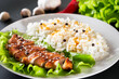 Homemade food - teriyaki chicken with white rice and pepper on a black background.