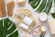 Cosmetics and natural skin and hair care accessories near monstera leaves, mockup
