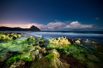 Wall Mural - the volcanic coast is illuminated by a flashlight on a starry night. monte cofano, sicily, italy.