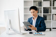 © Nuttapong punna - Business man using tablet and laptop for doing math finance on an office desk, tax, report, accounting, statistics, and analytical research concept in office