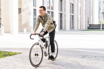The guy with the business bag uses environmentally friendly transport. A young man riding a bicycle in formal clothes came to work in the office.
