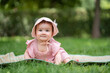 © TheVisualsYouNeed - adorable and happy baby girl outdoors in the park - portrait of 7 or 8 months old beautiful little child smiling cheerful sitting on mat on grass at city park wearing cozy hat and dress