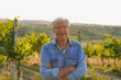 © Sabrina - Happy senior man smiling on camera with vineyard in the background