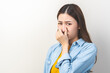 © KMPZZZ - Portrait of pretty brunette hair, disgust smell bad strong asian young woman, girl hand squeezing, covering nose with fingers, expression face disgusting, dislike odor isolated on white background.