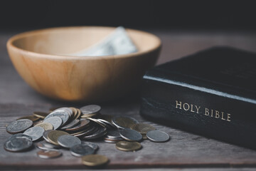 One tenth or tithe is basis on which Bible teaches us to donate one tenth of first fruit to God. Coins with Holy Bible. Religion donation and funding. Giving money, the symbol of Christianity donation