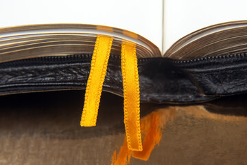 Wall Mural - Yellow ribbon bookmark for a book. Open bible. The study of literature.