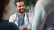 © Yeti Studio - Smiling male doctor communicating with a patient in his medical office