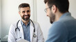 © Yeti Studio - Smiling male doctor communicating with a patient in his medical office