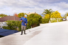 A Man Doing High Pressure Spray Cleaning Of A Roof In Preparation Of Painting, In Worcester, Western Cape, South Africa.