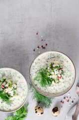 Wall Mural - Cold Okroshka Soup with Eggs, Vegetables, Meat, Herbs and Kefir on a Bright Background, Summer Soup