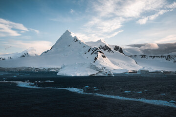 Wall Mural - Beautiful snow-capped mountains against the sunset sky in Antarctica. Global warming and travel concept for climate change. Arctic Greenland.