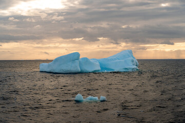 Wall Mural - Beautiful iceberg floating in the water. Photo taken at sunset in Antarctica and Arctic Greenland. Global warming and climate change and travel concept.