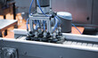 Automated robot arm lifting food can to conveyor belt in food industry.