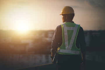 Engineer on a construction site at sunset. Working on the roof .