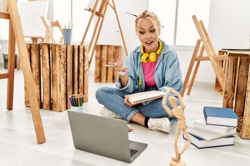 Sticker - Young caucasian woman artist having video call sitting on floor at art studio