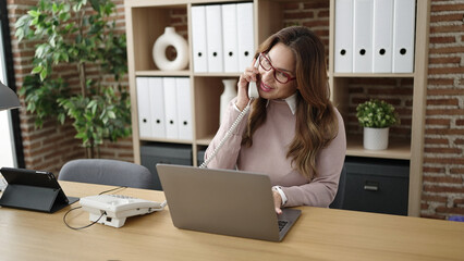 Sticker - Young beautiful hispanic woman business worker talking on telephone using laptop at office