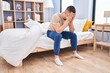 © Krakenimages.com - Young hispanic man stressed sitting on bed at bedroom