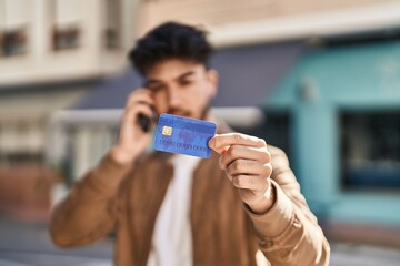 Sticker - Young hispanic man using smartphone and credit card at street