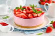 Strawberry no bake cheesecake decorated with fresh berries and mint on a plate. Summer dessert. Selective focus