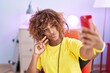 © Krakenimages.com - African american woman streamer make selfie by smartphone at gaming room