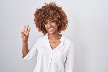 Sticker - Young hispanic woman with curly hair standing over white background showing and pointing up with fingers number three while smiling confident and happy.