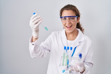 Poster - Young caucasian scientist woman working with laboratory samples smiling and laughing hard out loud because funny crazy joke.