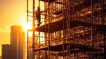 Construction Worker On Scaffolding In Industrial Construction During Sunset.