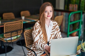 Wall Mural - Young caucasian woman using laptop sitting on table at restaurant