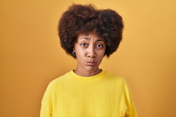 Wall Mural - Young african american woman standing over yellow background depressed and worry for distress, crying angry and afraid. sad expression.