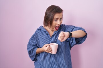 Canvas Print - Middle age hispanic woman drinking a cup coffee looking at the watch time worried, afraid of getting late