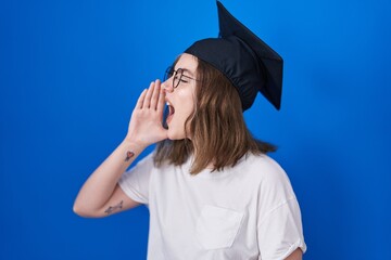 Poster - Blonde caucasian woman wearing graduation cap shouting and screaming loud to side with hand on mouth. communication concept.