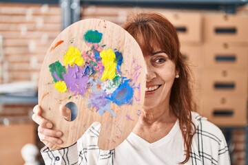 Poster - Middle age hispanic woman holding palette covering face smiling with a happy and cool smile on face. showing teeth.