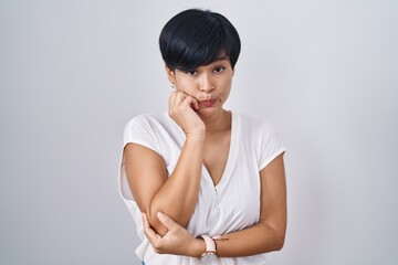 Sticker - Young asian woman with short hair standing over isolated background looking stressed and nervous with hands on mouth biting nails. anxiety problem.