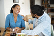 © Goran - Happy African American couple talking while enjoying in lunch time at dining table.