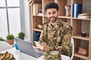 Sticker - Young arab man army soldier using laptop using smartphone at home