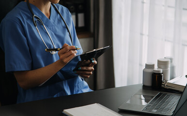 young doctor with diary sitting at desk in medical clinic