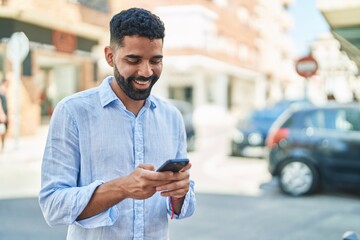 Sticker - Young arab man smiling confident using smartphone at street