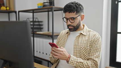 Sticker - Young hispanic man business worker using smartphone working at office