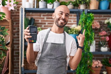 Sticker - Middle age bald man working at florist shop holding dataphone smiling happy pointing with hand and finger to the side