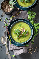 Green broccoli soup with cream and sunflower seeds.