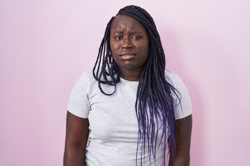 Canvas Print - Young african woman standing over pink background looking sleepy and tired, exhausted for fatigue and hangover, lazy eyes in the morning.