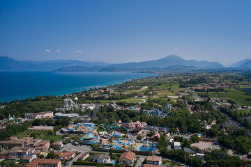 Wall Mural - Amusement park, attractions on Lake Garda in Italy, aerial view. Aerial panorama of the popular amusement park on Lake Garda. Sights of Italy.